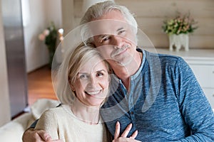 Head shot portrait happy attractive aged spouses at home