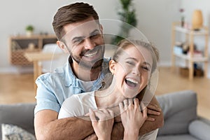 Head shot portrait of happy excited young couple in love at home