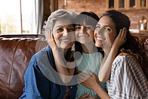 Head shot portrait happy three generations of women hugging