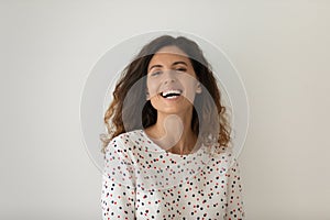 Head shot portrait of laughing excited woman on grey background