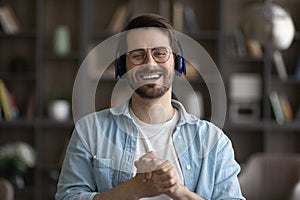 Head shot portrait laughing man in headphones looking at camera