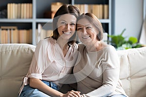 Head shot portrait mature woman with grown up daughter hugging