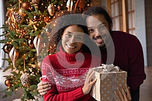 Head shot portrait smiling African American couple with Christmas gift