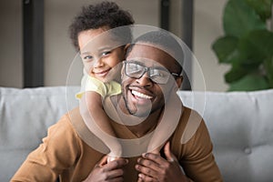 Head shot portrait of smiling African American father piggyback son