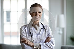 Head shot portrait smiling female doctor with arms crossed