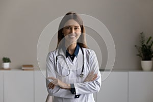 Head shot portrait smiling female doctor therapist with arms crossed