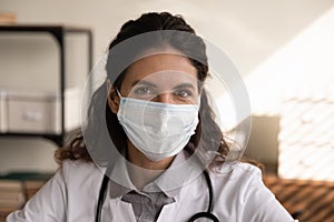 Head shot portrait smiling female doctor wearing protective mask