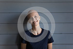 Head shot portrait smiling hairless woman on grey background