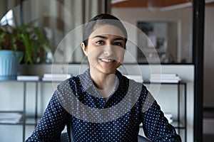 Head shot portrait smiling Indian businesswoman looking at camera