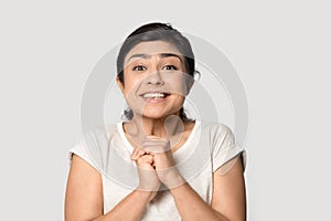 Head shot portrait smiling Indian girl joining hands with excitement