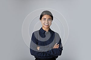 Head shot portrait smiling Indian woman with arms crossed