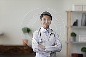 Head shot portrait smiling Indian woman doctor with folded hands