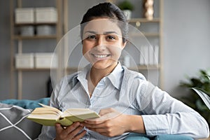 Head shot portrait smiling Indian woman holding favorite book photo
