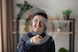 Head shot portrait smiling Indian woman pointing finger at camera