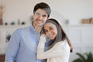 Head shot portrait smiling man and woman hugging, standing