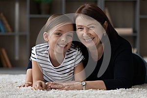 Head shot portrait of smiling mature grandmother and little granddaughter