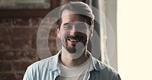 Head shot portrait of smiling millennial 35s man posing indoor