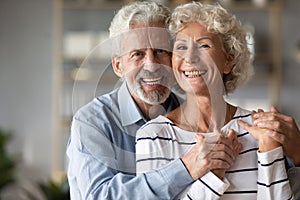 Head shot portrait smiling older wife and husband hugging
