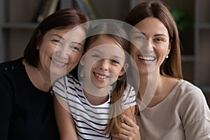 Head shot portrait of smiling three generations of women together