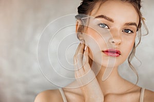 Head shot portrait smiling woman touching perfect smooth face skin