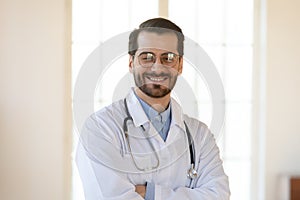 Head shot portrait smiling young man doctor wearing glasses