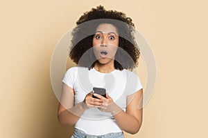 Head shot portrait surprised African American girl using phone