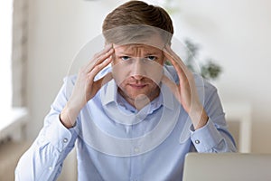 Head shot portrait of thoughtful businessman touching temples