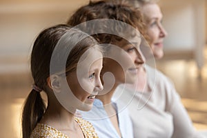 Head shot profile portrait of smiling three generations of women