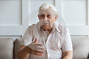 Head shot serious older man looking at camera and talking