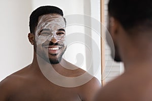 Head shot smiling African American man enjoying skincare procedure