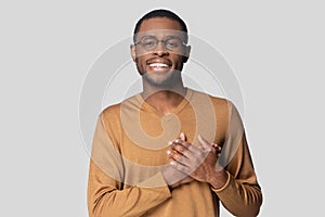 Head shot smiling African American man keeping hands on chest