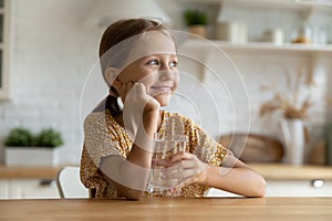 Head shot smiling dreamy little girl holding glass of water