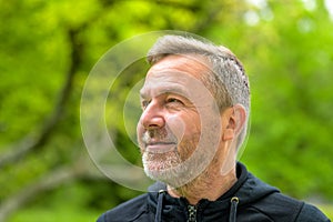 Head shot of a smiling middle-aged man outdoors in a park