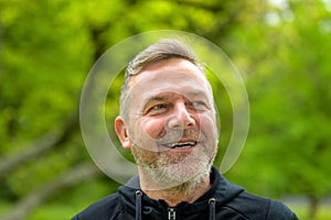 Head shot of a smiling middle-aged man outdoors in a park