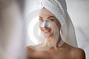 Head shot smiling woman with anti blackhead mask on nose