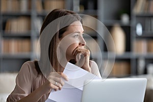 Head shot stressed young woman thinking of financial troubles.