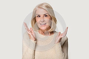 Head shot of surprised elderly woman showing sincere amazement emotions