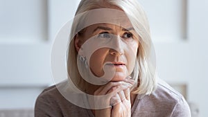 Head shot unhappy upset older woman thinking about problems