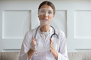 Head shot woman doctor talking online with patient, video call