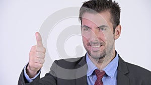 Head shot of young happy Hispanic businessman giving thumbs up