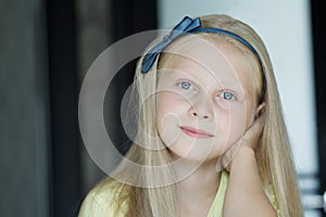 Head and shoulders indoors portrait of teenage girl with blue eyes and fair hair