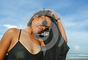 Head and shoulders lifestyle portrait of young beautiful and sexy Asian girl in bikini and sunglasses enjoying holidays at