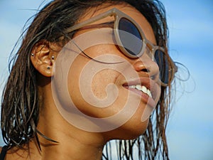 Head and shoulders lifestyle portrait of young beautiful and sexy Asian girl in bikini and sunglasses enjoying holidays at