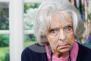 Head And Shoulders Portrait Of Angry Senior Woman At Home