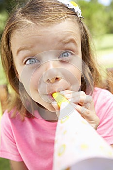 Head And Shoulders Portrait Of Girl Blowing Party Hooter