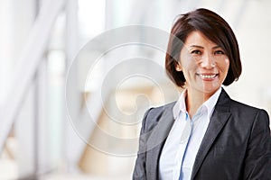 Head and shoulders portrait of smiling Asian businesswoman