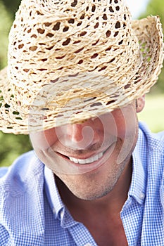 Head And Shoulders Portrait Of Smiling Man With Sun Hat