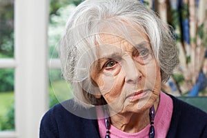 Head And Shoulders Portrait Of Thoughtful Senior Woman At Home