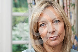 Head And Shoulders Portrait Of Unhappy Mature Woman At Home