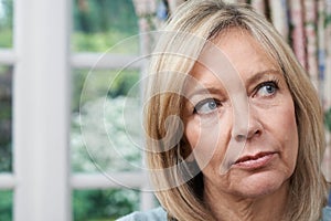 Head And Shoulders Portrait Of Unhappy Mature Woman At Home